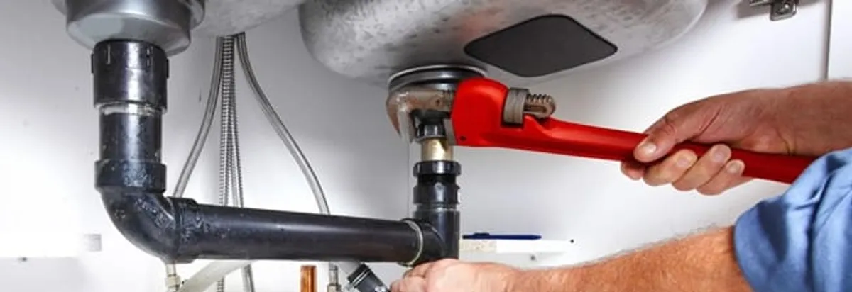 Garbage disposal repair technician tightening the sink drain and disposal connection in Dover, DE