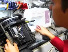 Vacuum repair technician servicing internal components on a workbench in Dover, DE