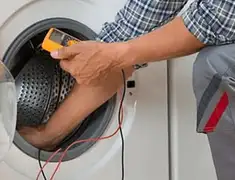 Washing machine repair technician testing a front-load washer with diagnostic tools in Dover, DE